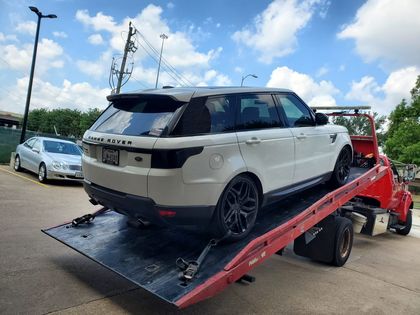 White Range Rover secured on a red flatbed