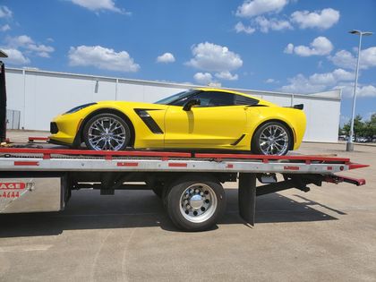 Yellow sports car transported on a flatbed