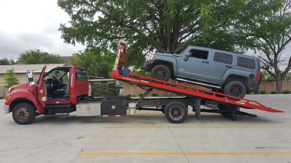 Gray SUV being loaded onto a red flatbed